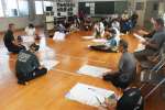 鹿屋市の担当者の防災講話に聞き入る参加者ら＝同市の寿小学校
