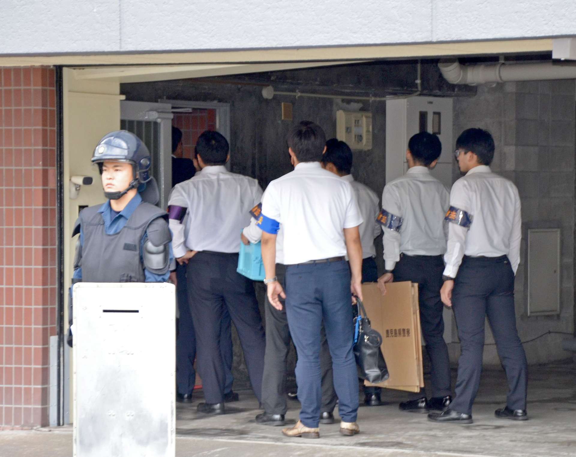 小桜一家本部事務所に家宅捜索に入る鹿児島県警の捜査員＝２５日午前１０時５分、鹿児島市甲突町