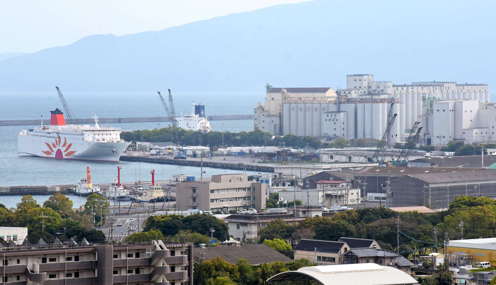 巨大な配合飼料工場（中央右）などが立ち並ぶ志布志港＝４月１６日、志布志市志布志