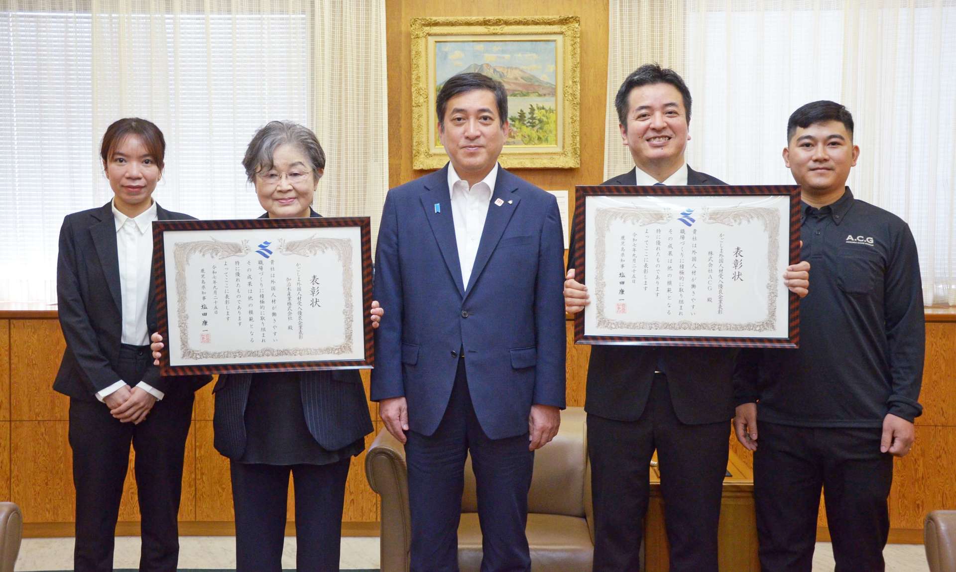 外国人材の受け入れに尽力したとして、表彰された２企業の代表者ら＝２５日、県庁