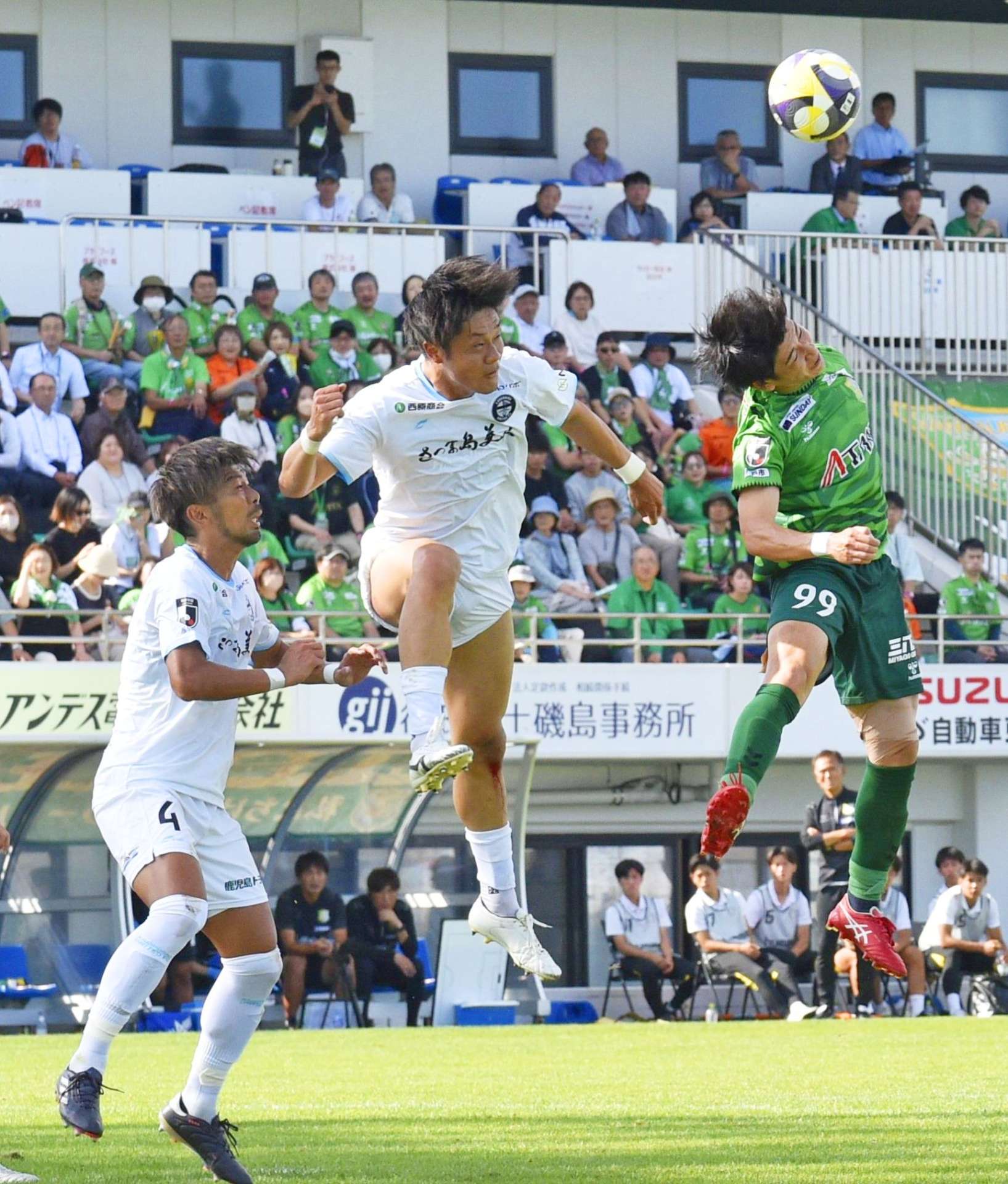自陣ゴール前で競り合う鹿児島ＵのＦＷ近藤（空中左）＝プライフーズスタジアム