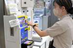１割の加算廃止を前に、交通ＩＣカードを積み増す利用者＝２５日、鹿児島市役所本庁