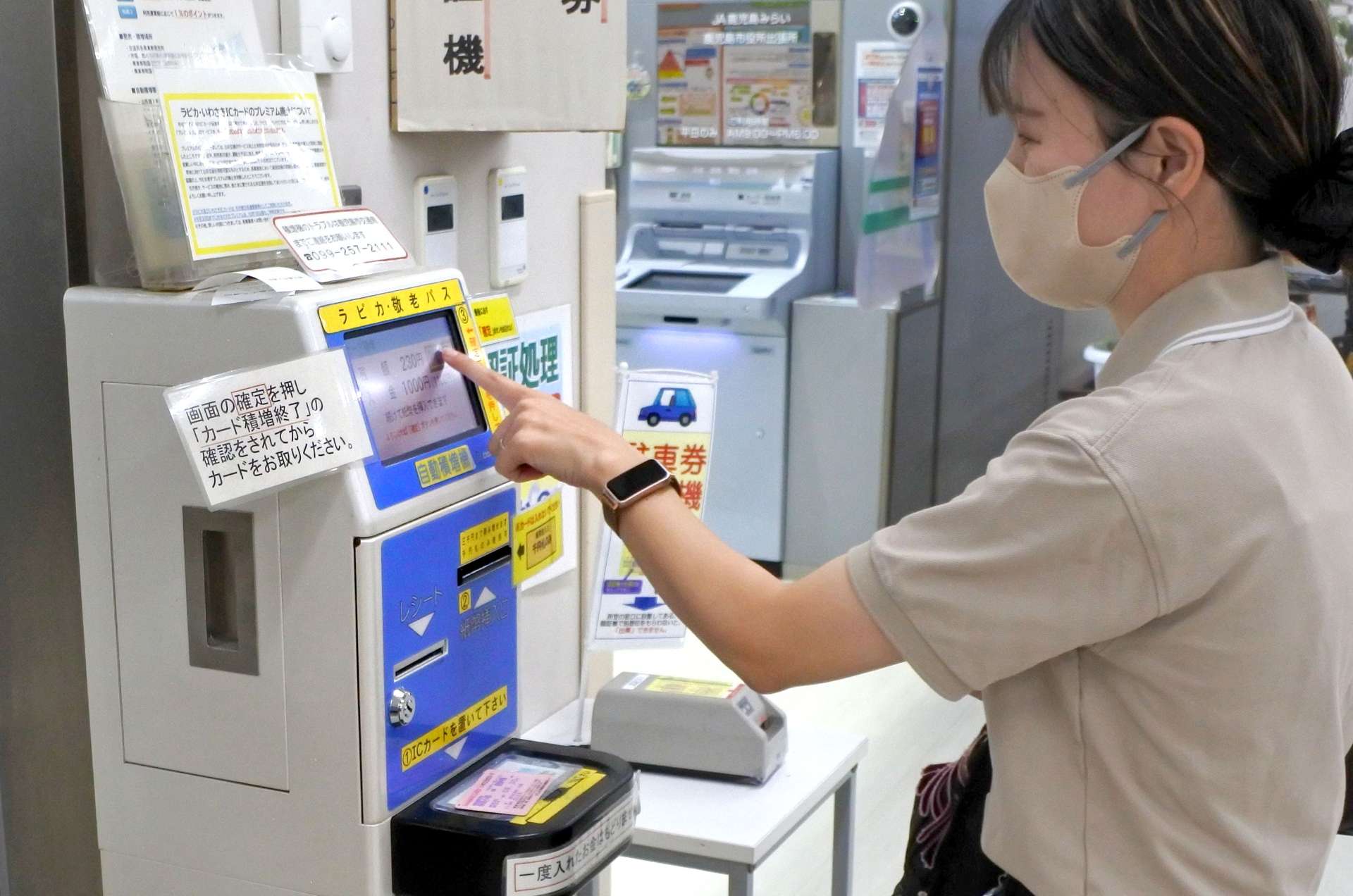 １割の加算廃止を前に、交通ＩＣカードを積み増す利用者＝２５日、鹿児島市役所本庁
