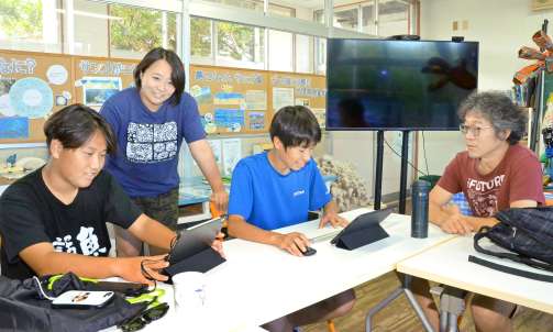 　サンゴ留学生を指導する渡邊剛理事長（右）ら＝８月、喜界町塩道の喜界島サンゴ礁科学研究所