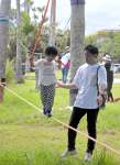 （上）スラックラインに挑戦する親子連れ＝指宿市の指宿総合体育館多目的広場