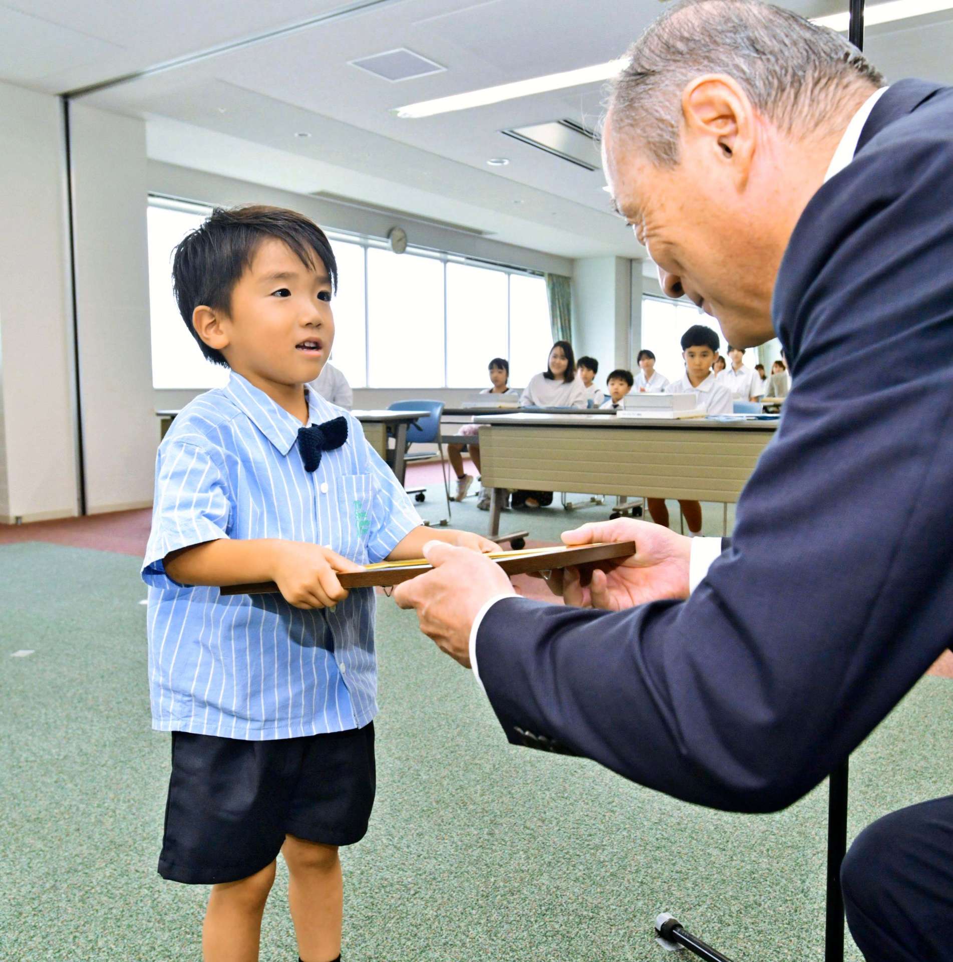 南日本新聞社賞の賞状を受け取る丹羽健人ちゃん（あさひ保育園）＝２７日、鹿児島市の南日本新聞社