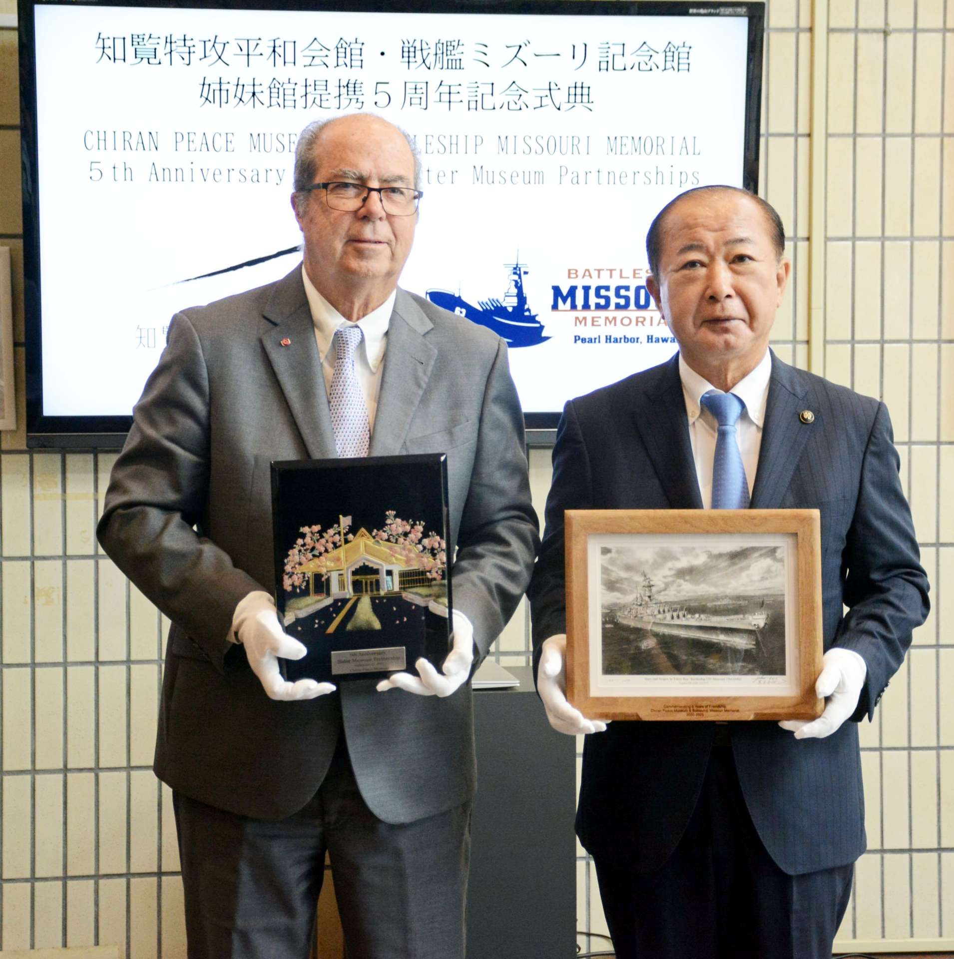 記念品を交換し、恒久平和を誓うマイク・カー会長（左）と塗木弘幸市長＝２７日、南九州市の知覧特攻平和会館