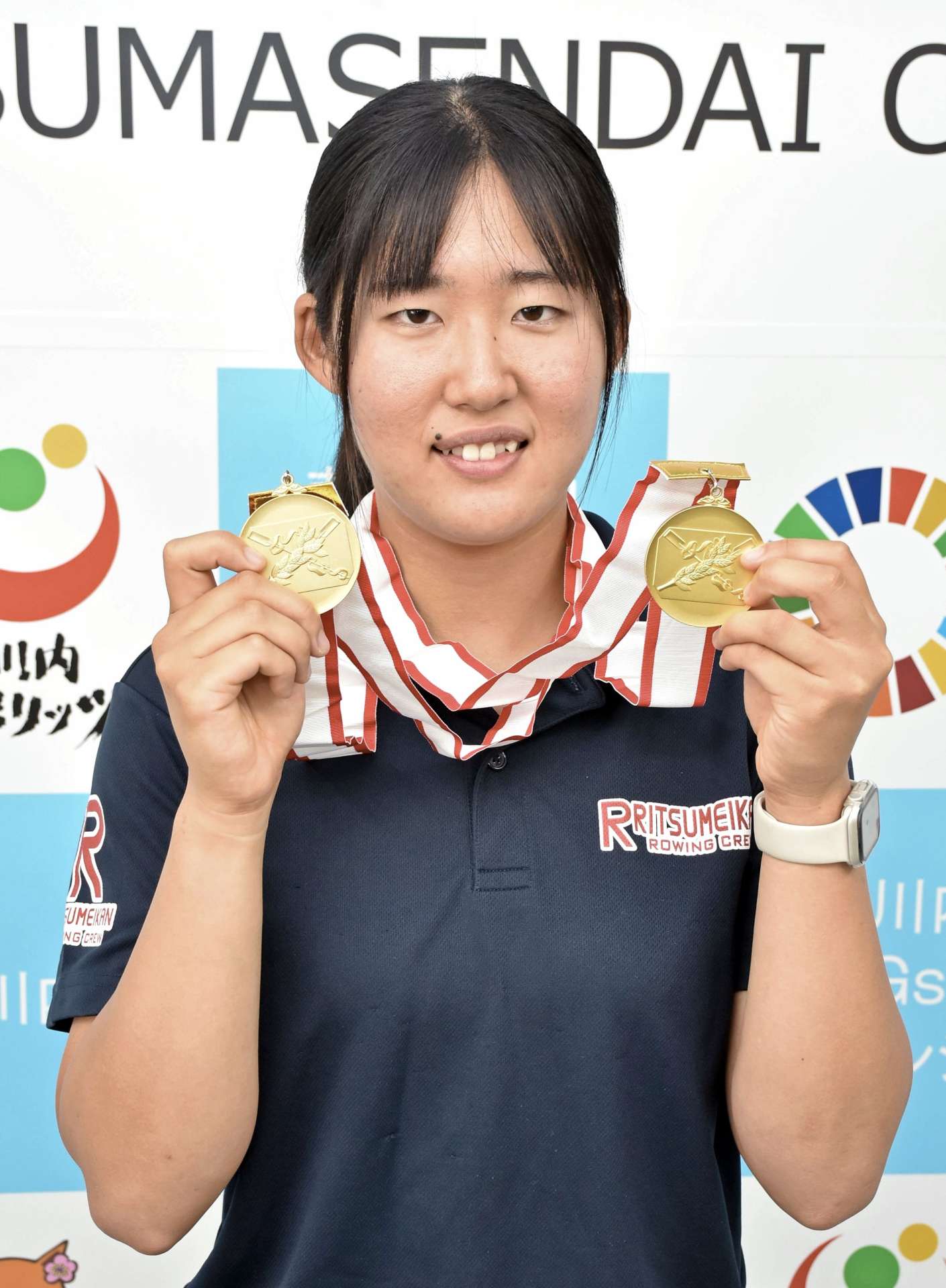 日本一のメダルを手に笑顔を見せる林奈央さん＝薩摩川内市役所