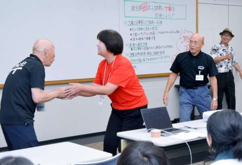 寸劇で「げんね（はずかしい）」場面を演じる団員（右から２人目）＝鹿児島市のカクイックス交流センター