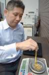 金の重さを量るスタッフ＝２９日、鹿児島市の質屋アシスト宇宿店