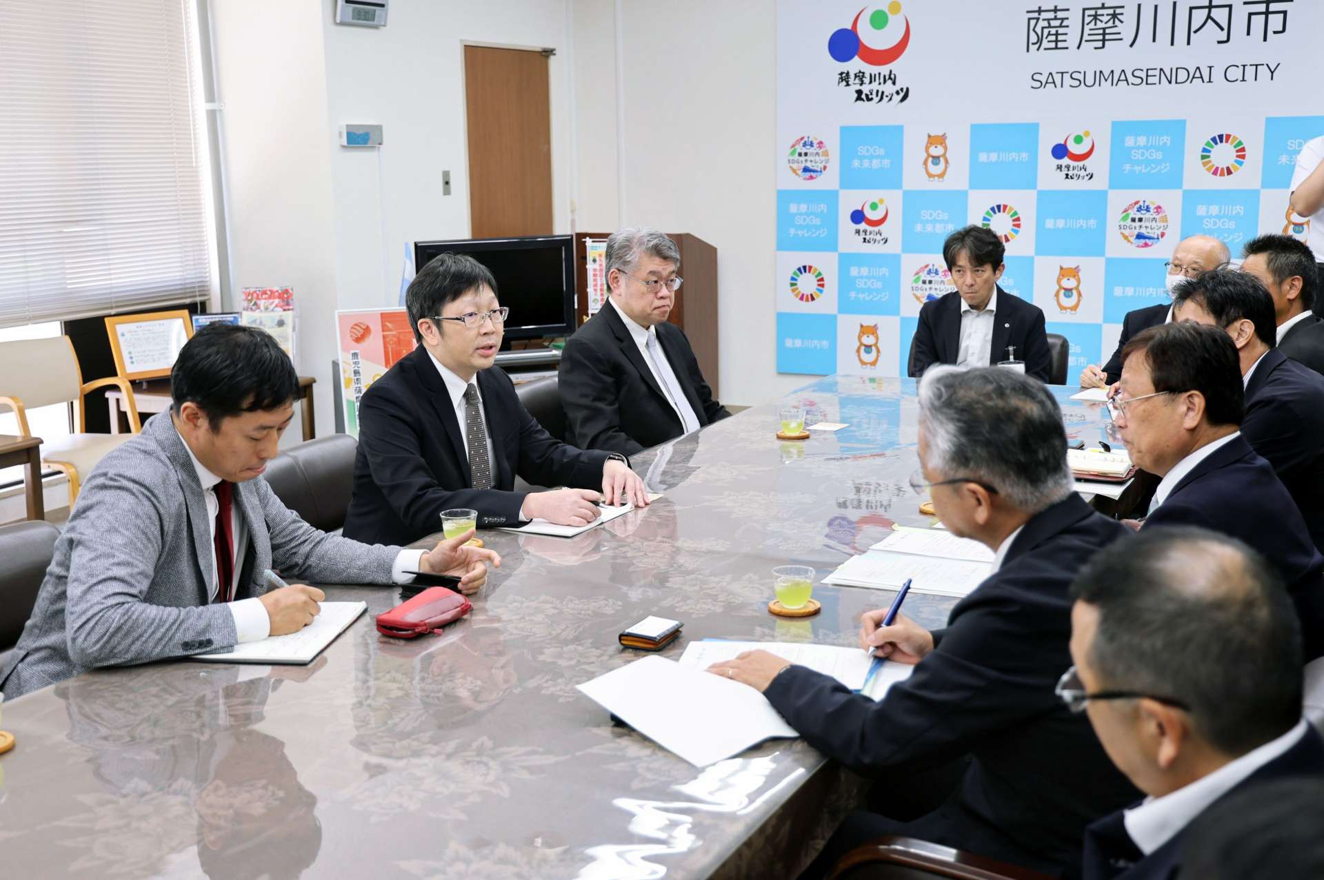 データセンター計画について説明するＣＤＩＢキャピタルグループのダニエル・ツォ副社長（左から２人目）ら＝３０日、薩摩川内市役所