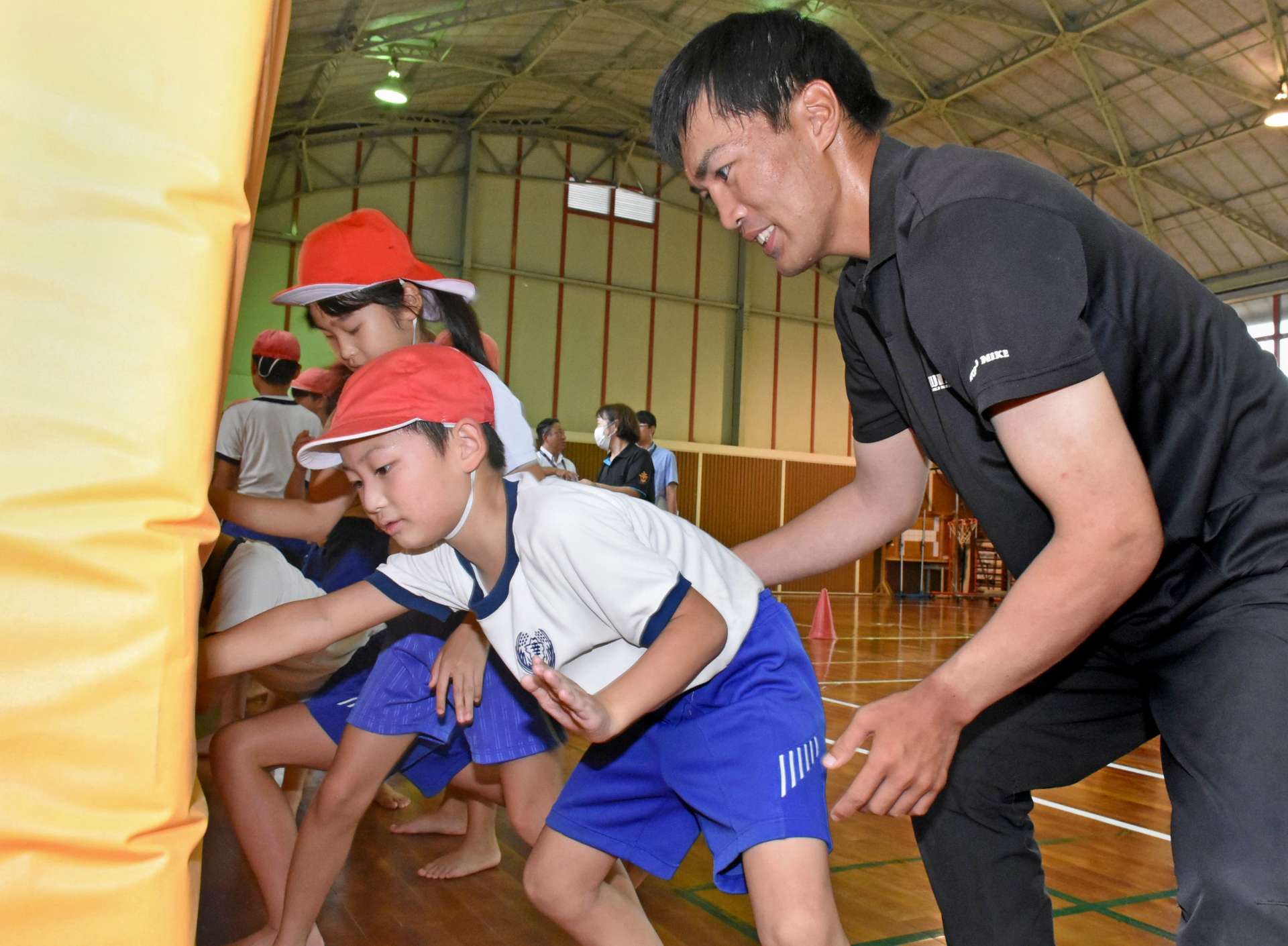 児童にてっぽうを指導する元力士「湧水」の前田隆貴さん＝湧水町の幸田小学校
