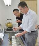 池田製茶の池田研太社長から茶の鑑定方法を学ぶチリの茶専門店関係者（手前）＝３０日、鹿児島市の同製茶