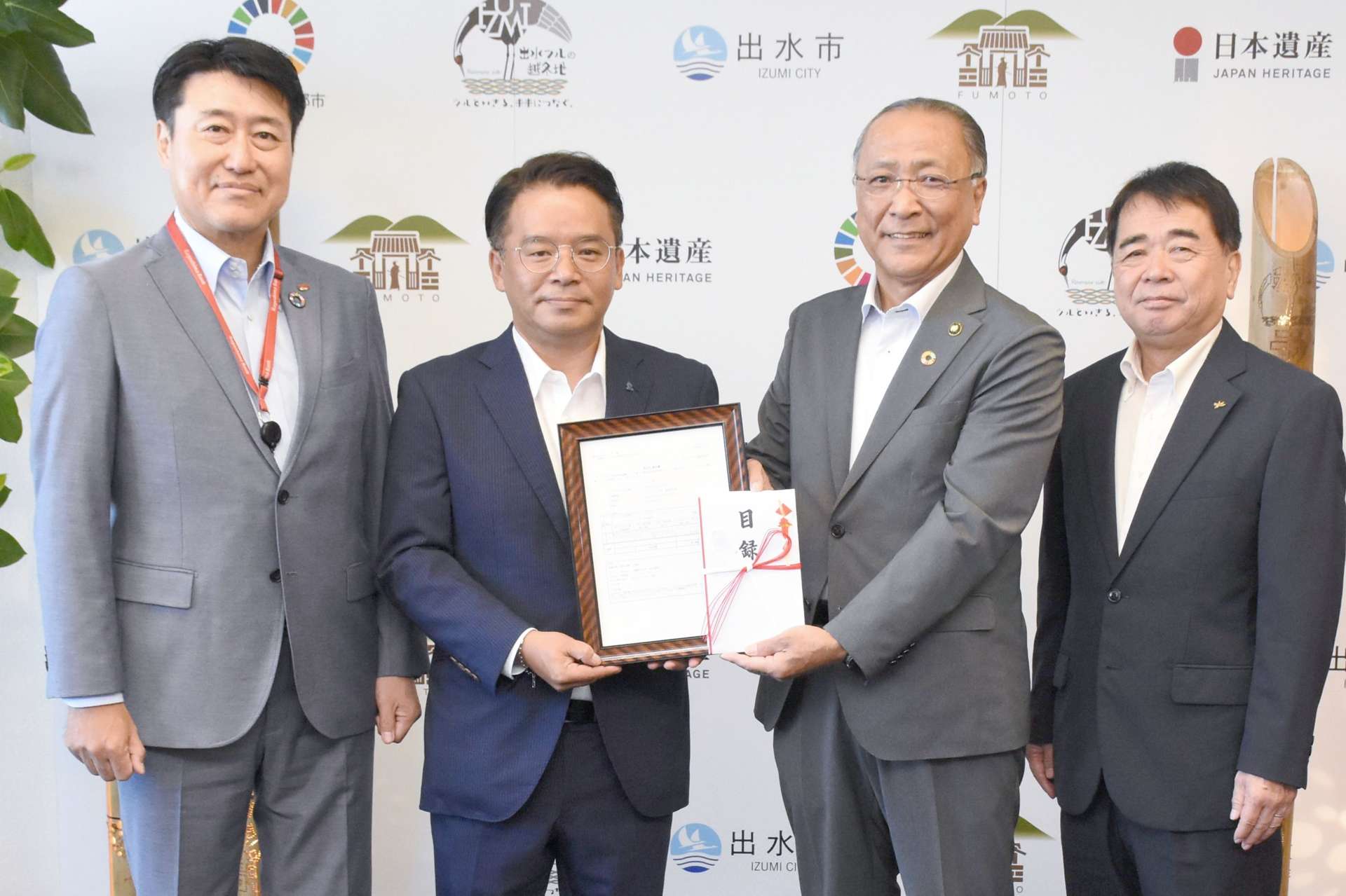 椎木伸一市長（左から３人目）に無効化通知書を手渡した瀬涯洋介社長（同２人目）＝３０日、出水市役所