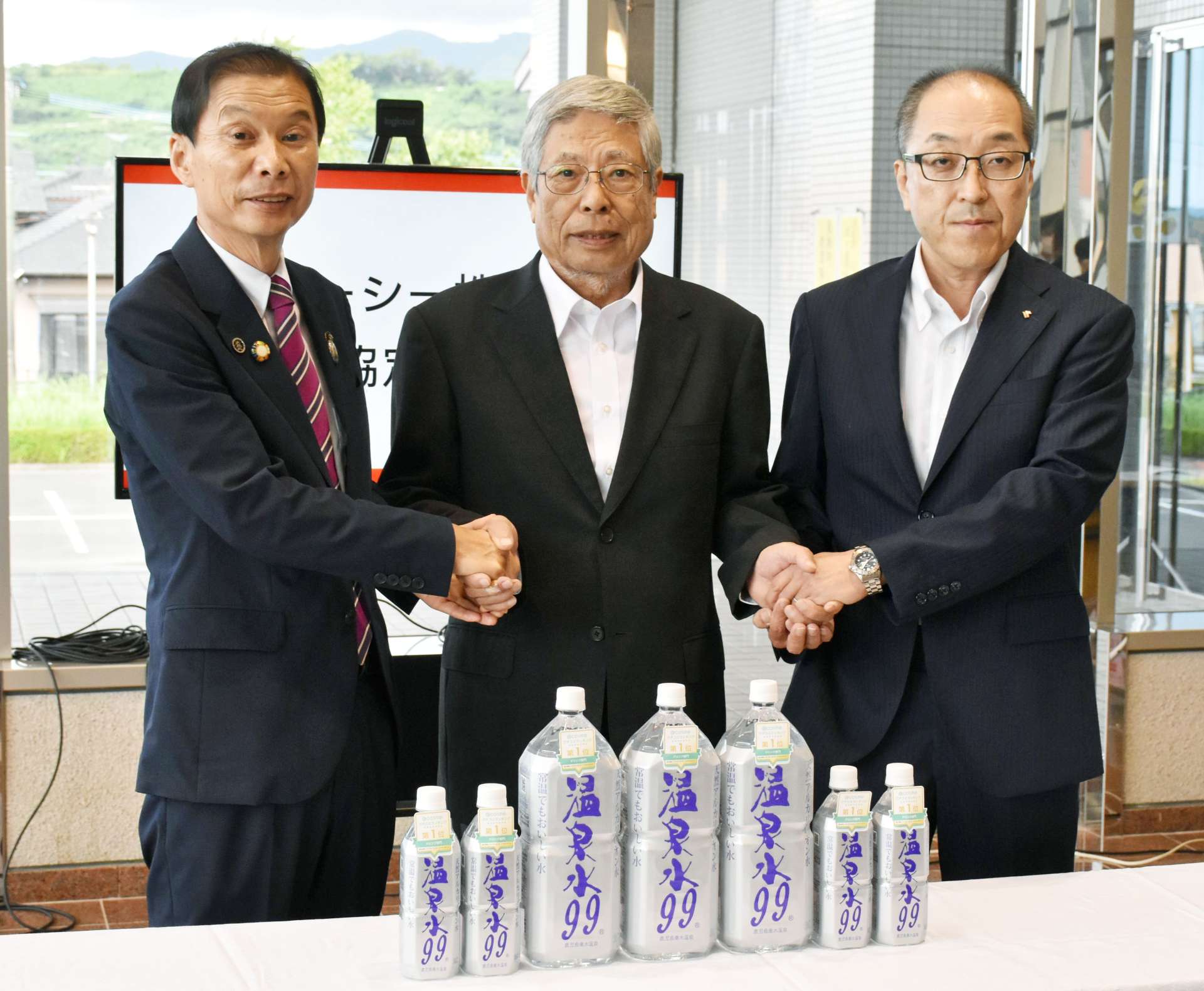立地協定を結んだ草間茂行社長（中央）と尾脇雅弥市長（左）＝垂水市文化会館