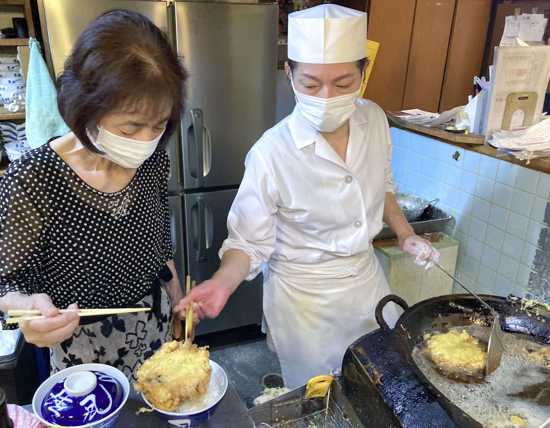 名物のかき揚げを丼に盛る上原由美さん（右）と母の松崎初美さん＝９月２５日、鹿児島市下荒田１丁目
