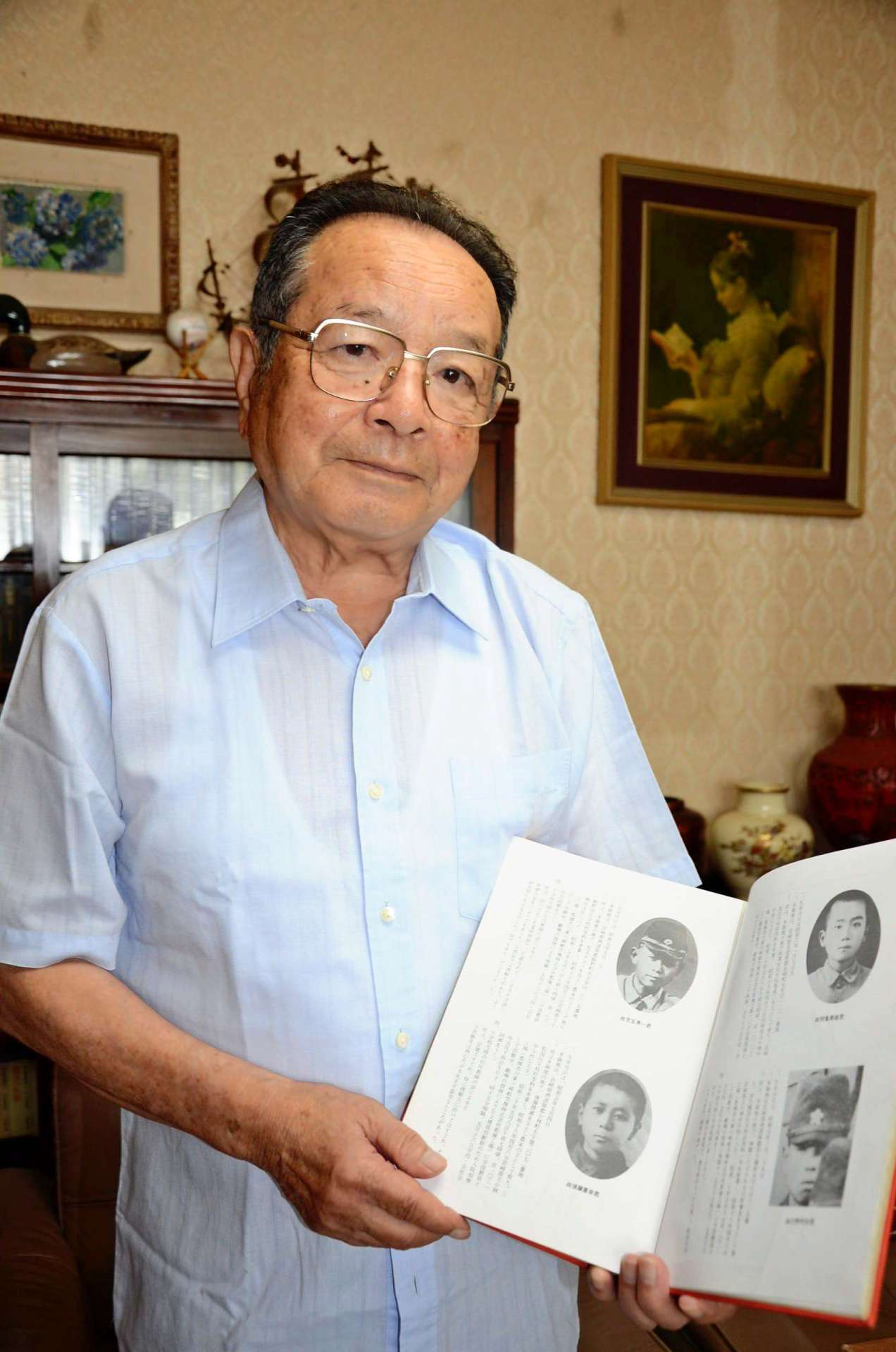 記録誌を手に「二度と戦争をしてはならない」と語る川野八郎さん＝小林市堤