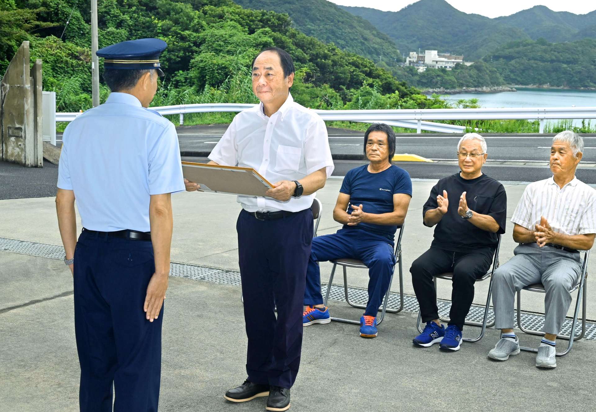 釣り人を救助し表彰される織田酉男さんら＝南さつま市坊津町泊