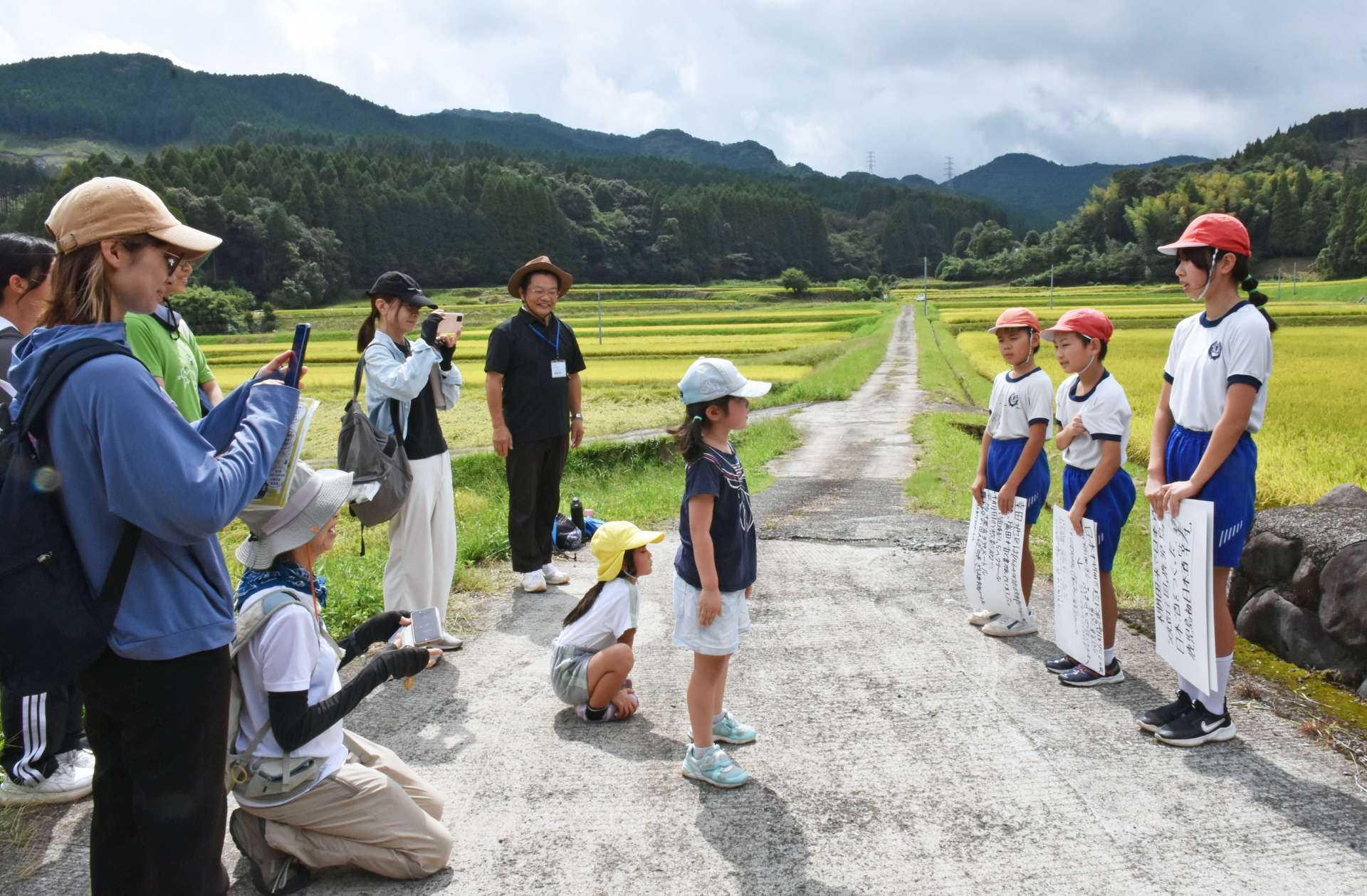 幸田小学校児童による棚田の特長などの発表を聞くウオーキング参加者ら＝湧水町幸田
