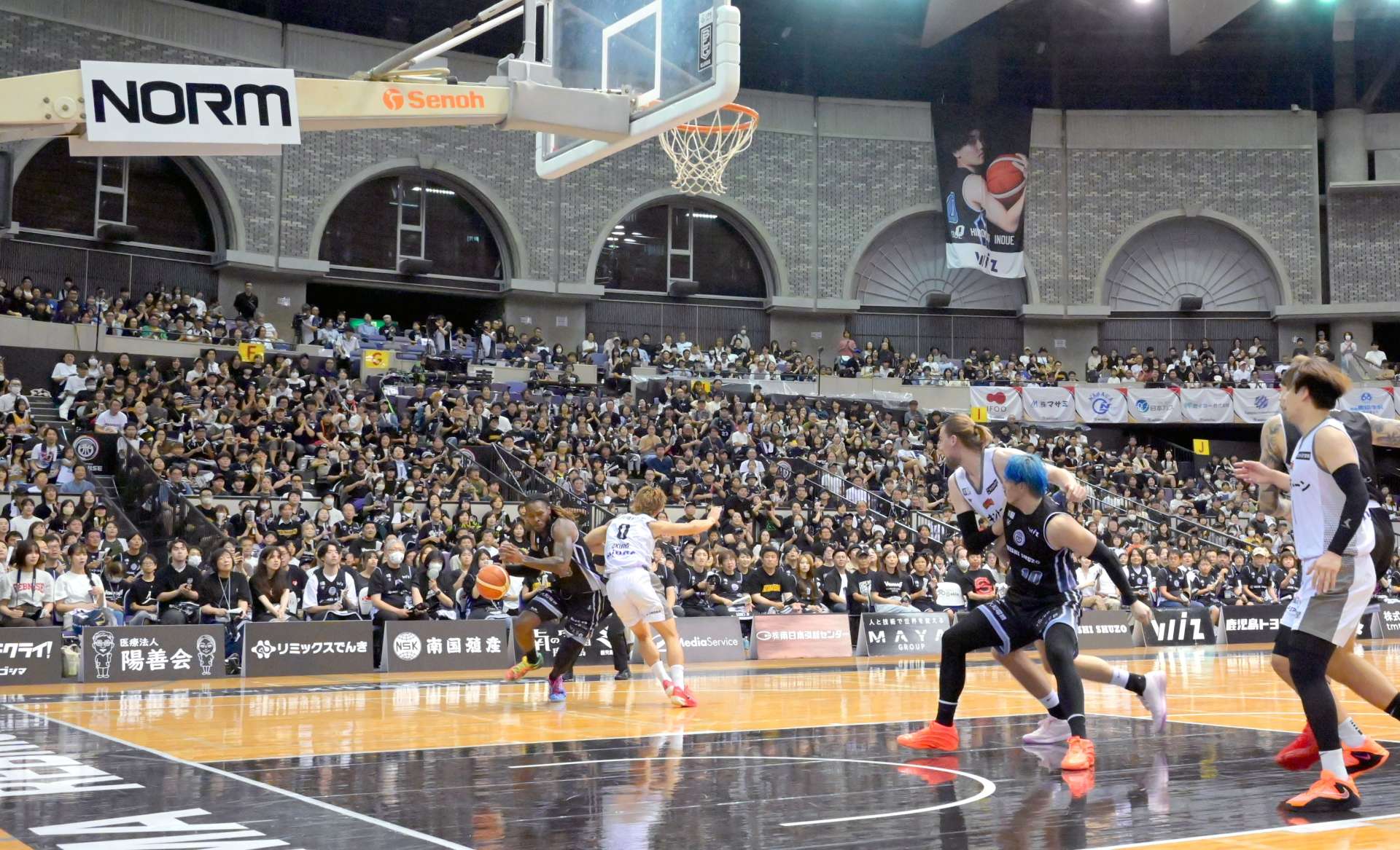 プロ選手の迫力あるプレーを楽しむ大勢の観客ら＝５日午後、鹿児島市の西原商会アリーナ