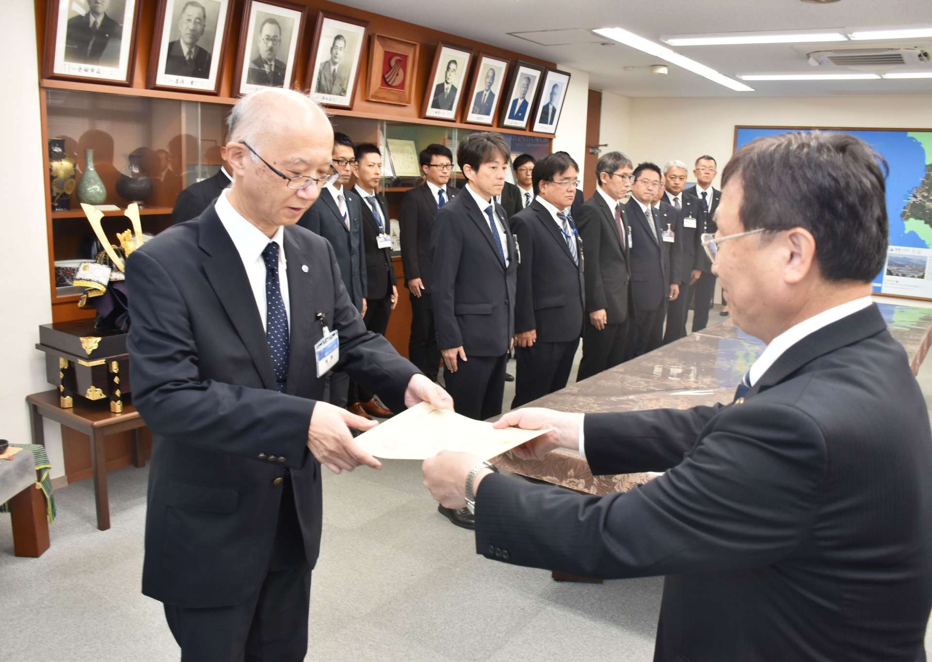 辞令を受け取るリーダーの有馬眞二郎部長（左）＝薩摩川内市役所