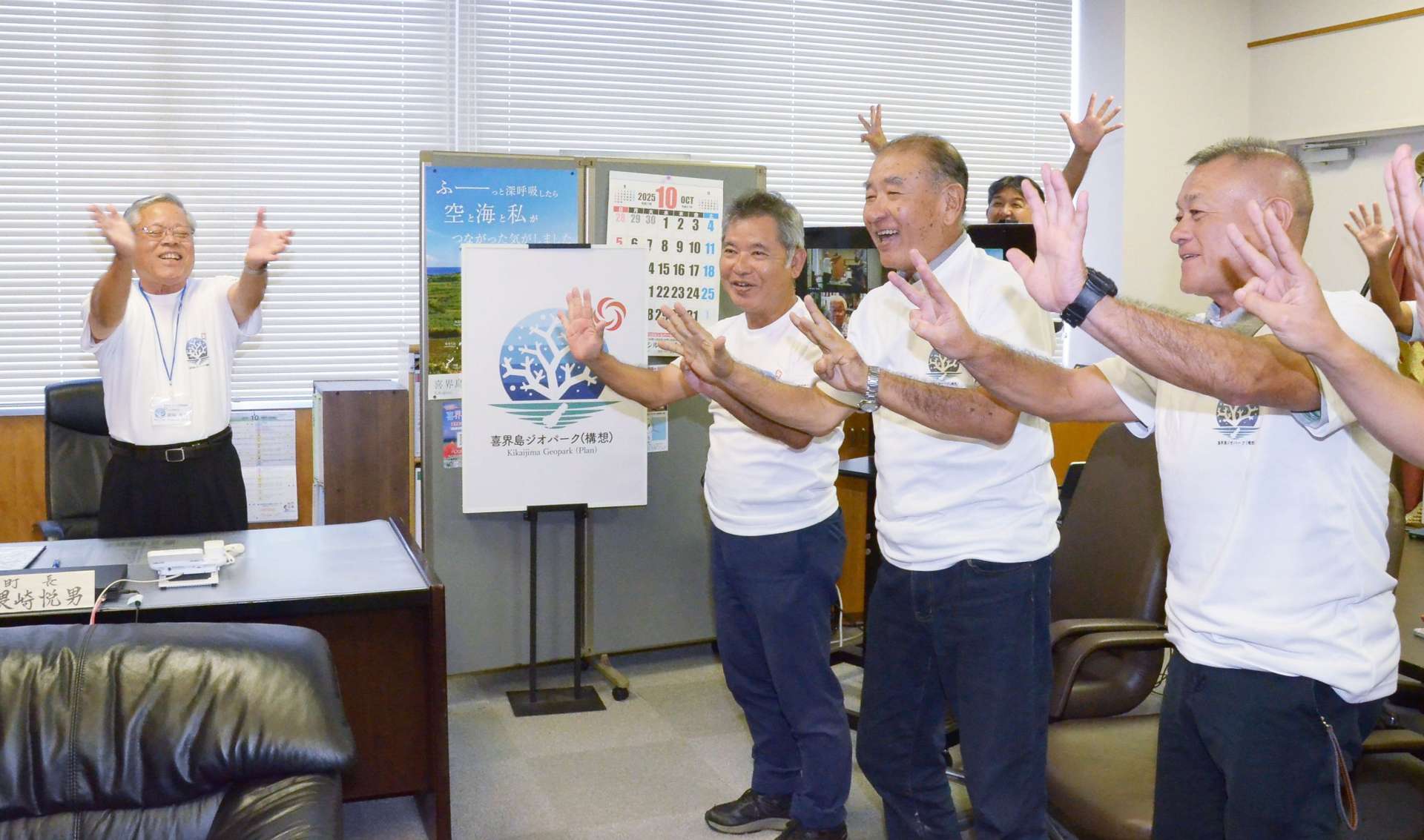 日本ジオパーク認定の知らせに喜ぶ喜界町の隈崎悦男町長（左）ら＝６日、同町役場