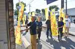 国道１０号沿いに黄色い旗を立てる網掛橋復興臨時通り会のメンバー＝７日、姶良市加治木