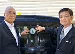 タクシーにステッカーを貼る県タクシー協会の迫田省三副会長（写真左）と県移植医療アイバンク推進協会の牧角寛郎理事長＝７日、鹿児島市
