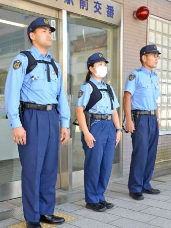 半袖のポロシャツ型制服を着る警察官（右）と、ファン付きベストを着用する警察官（左、中央）＝６日、鹿児島市の鹿児島中央駅前交番