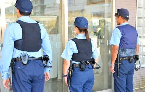 （後ろからポロシャツ型制服を見る）空調ベストを着用する警察官＝６日午後１時半ごろ、鹿児島市の鹿児島中央駅前交番