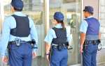 （後ろからポロシャツ型制服を見る）空調ベストを着用する警察官＝６日午後１時半ごろ、鹿児島市の鹿児島中央駅前交番