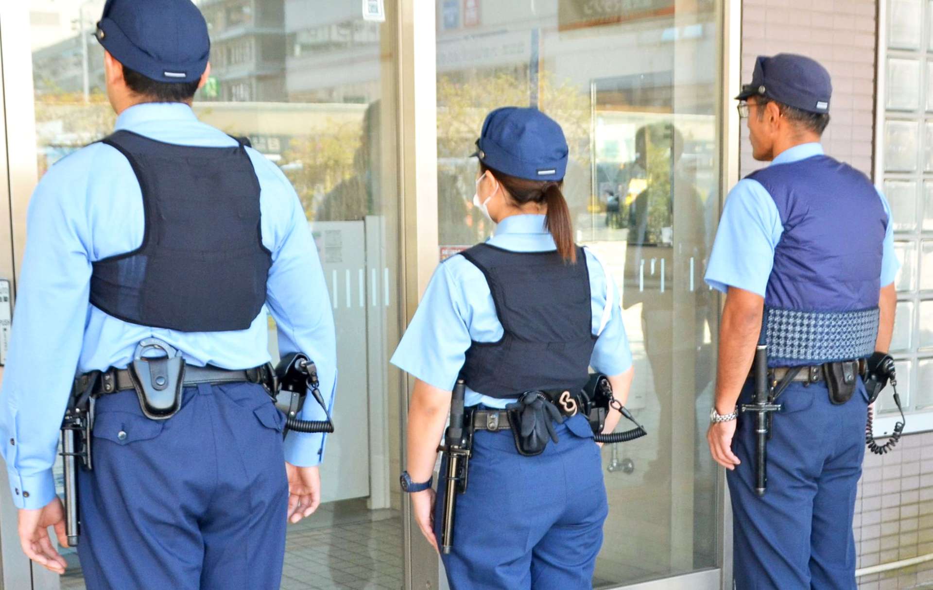 （後ろからポロシャツ型制服を見る）空調ベストを着用する警察官＝６日午後１時半ごろ、鹿児島市の鹿児島中央駅前交番