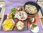 参加者が試食した山形と鹿児島の郷土料理。写真中央が「あけびの肉詰め」＝鹿児島市のカクイックス交流センター