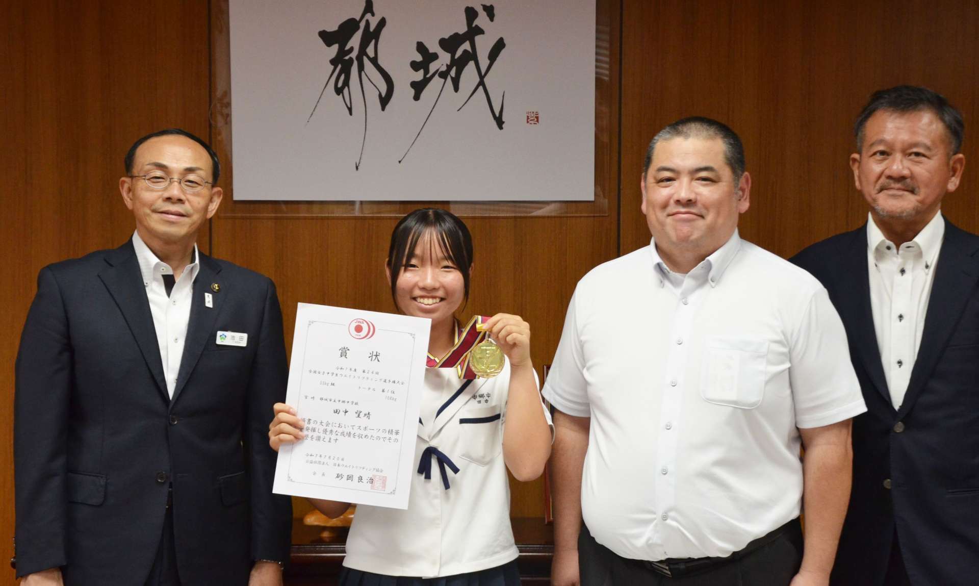 優勝報告をした田中望晴さん（左から２人目）＝都城市姫城町の市役所