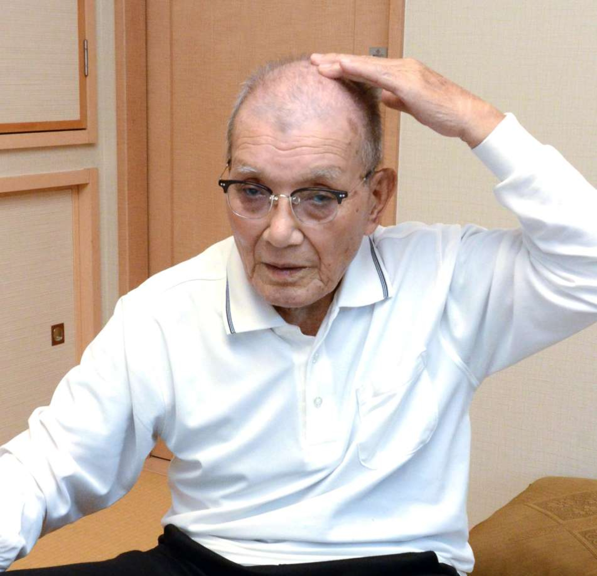 中国人の投げた石でけがをした頭部をなでる久保敏憲さん＝１０日、鹿児島市田上６丁目