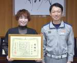 感謝状を手にする花原千尋さん（左）と、救命作業を引き継いだ救急隊員の夫、友志朗さん＝都城市役所
