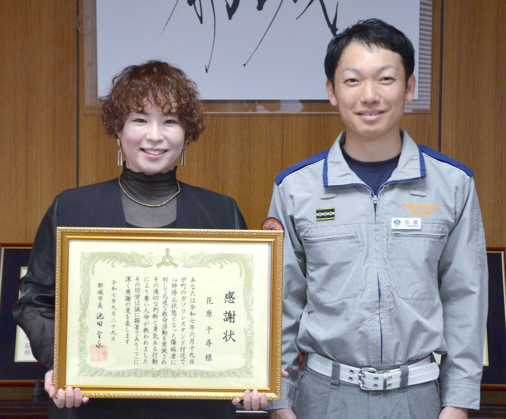感謝状を手にする花原千尋さん（左）と、救命作業を引き継いだ救急隊員の夫、友志朗さん＝都城市役所