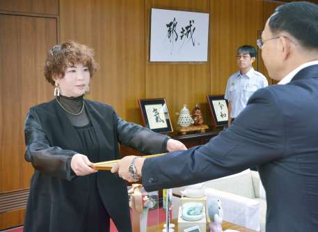 池田宜永市長（右）から感謝状を贈られる花原千尋さん＝都城市役所