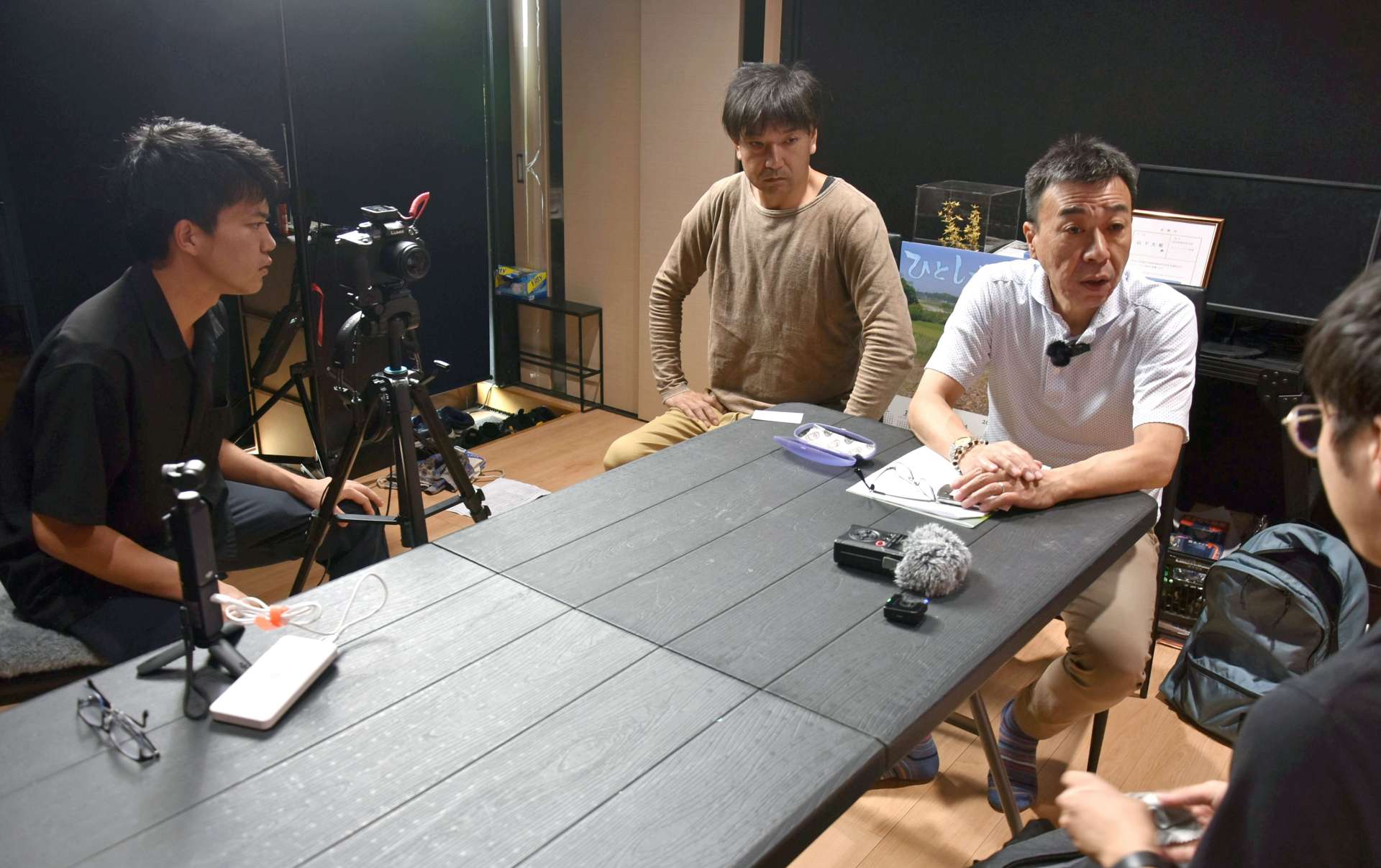 （別カット）住民インタビューの様子を撮影する山下大裕監督（左端）＝南大隅町根占川北