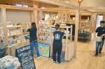 商品を棚に並べ、営業再開に向けた準備を進める日当山無垢食堂のスタッフ＝８日、霧島市隼人町内の日当山無垢食堂