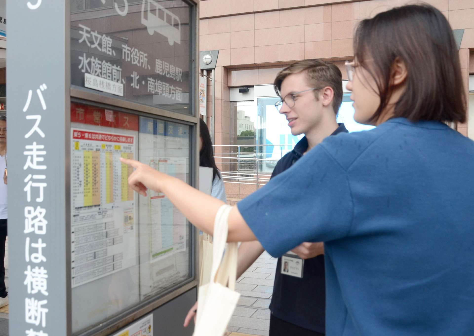 ＪＲ鹿児島中央駅から観光地までのルートをたどる鹿児島市の国際交流アドバイザーら＝同市中央町