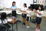 ペットボトルの簡単なつぶし方に挑戦する児童＝出水市の切通小学校
