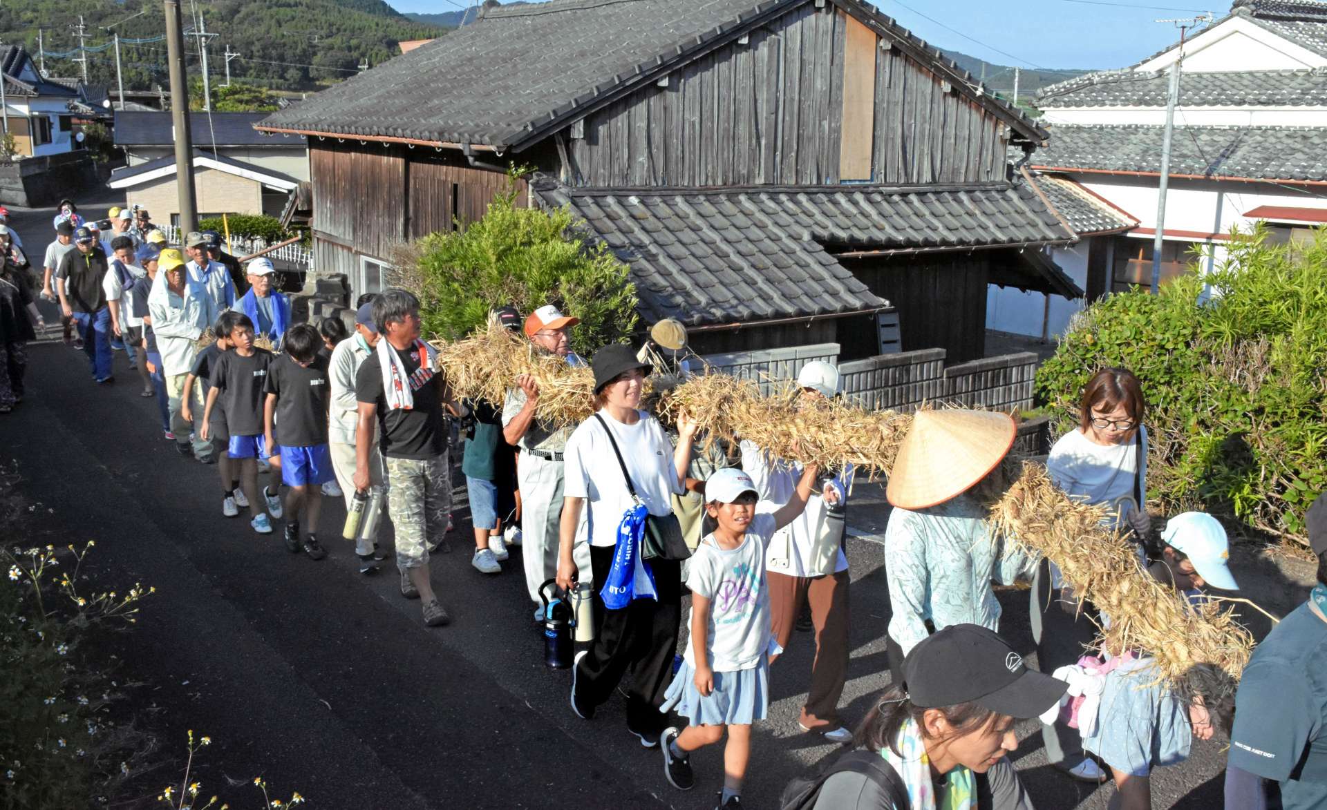 綱を担いで集落を練り歩く参加者＝５日、指宿市山川大山