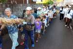綱を担いで集落を練り歩く参加者＝５日、指宿市山川大山
