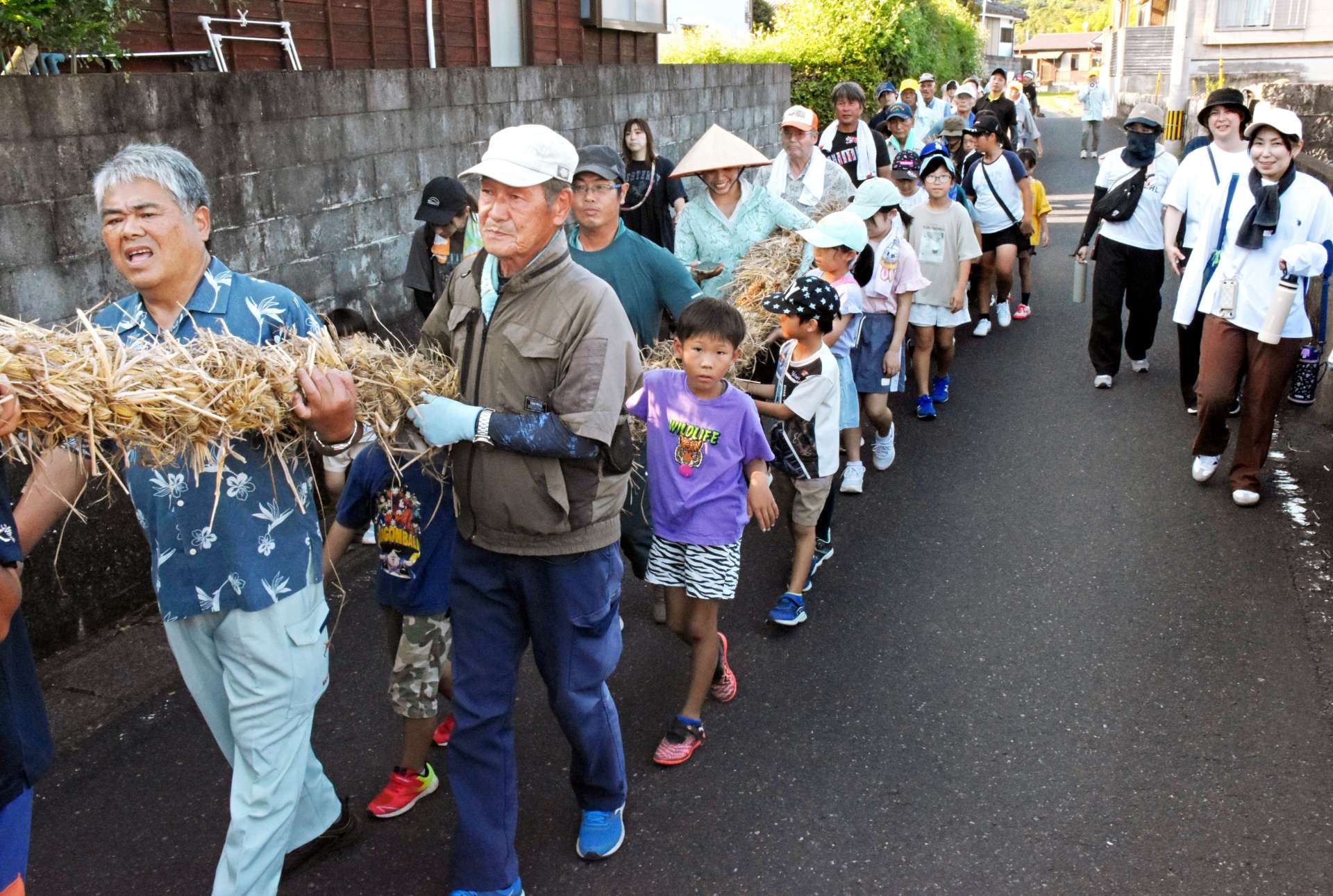 綱を担いで集落を練り歩く参加者＝５日、指宿市山川大山