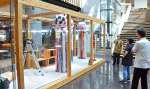 都城市立図書館関係者と相談しながら「千日夜市」の告知スペースの展示に当たる鎌田美里さん（写真右から３人目）＝同市中町
