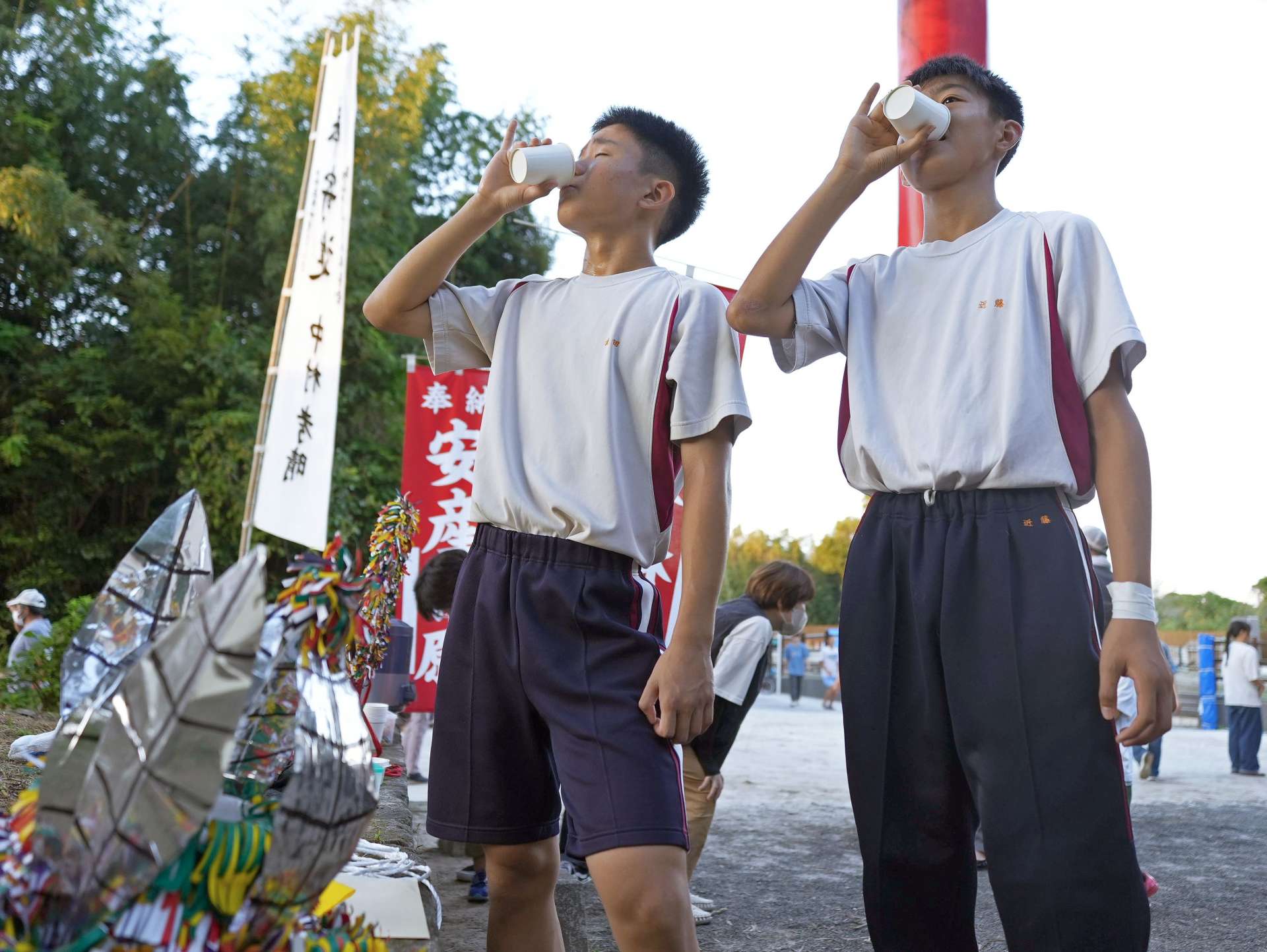 高山流鏑馬の練習後、水分補給をする中学生＝１２日、肝付町の四十九所神社