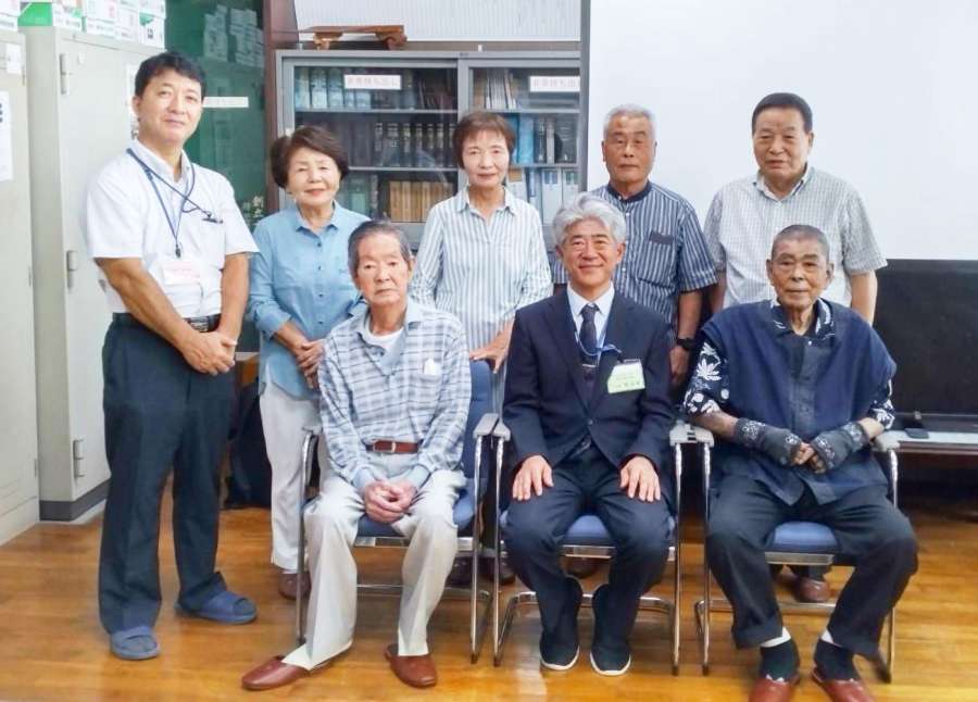 校長室で記念撮影をする南中学校の第１期生＝同校