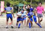 熱戦を繰り広げるビーチタグラグビー参加者＝大崎町ビーチスポーツ専用競技場