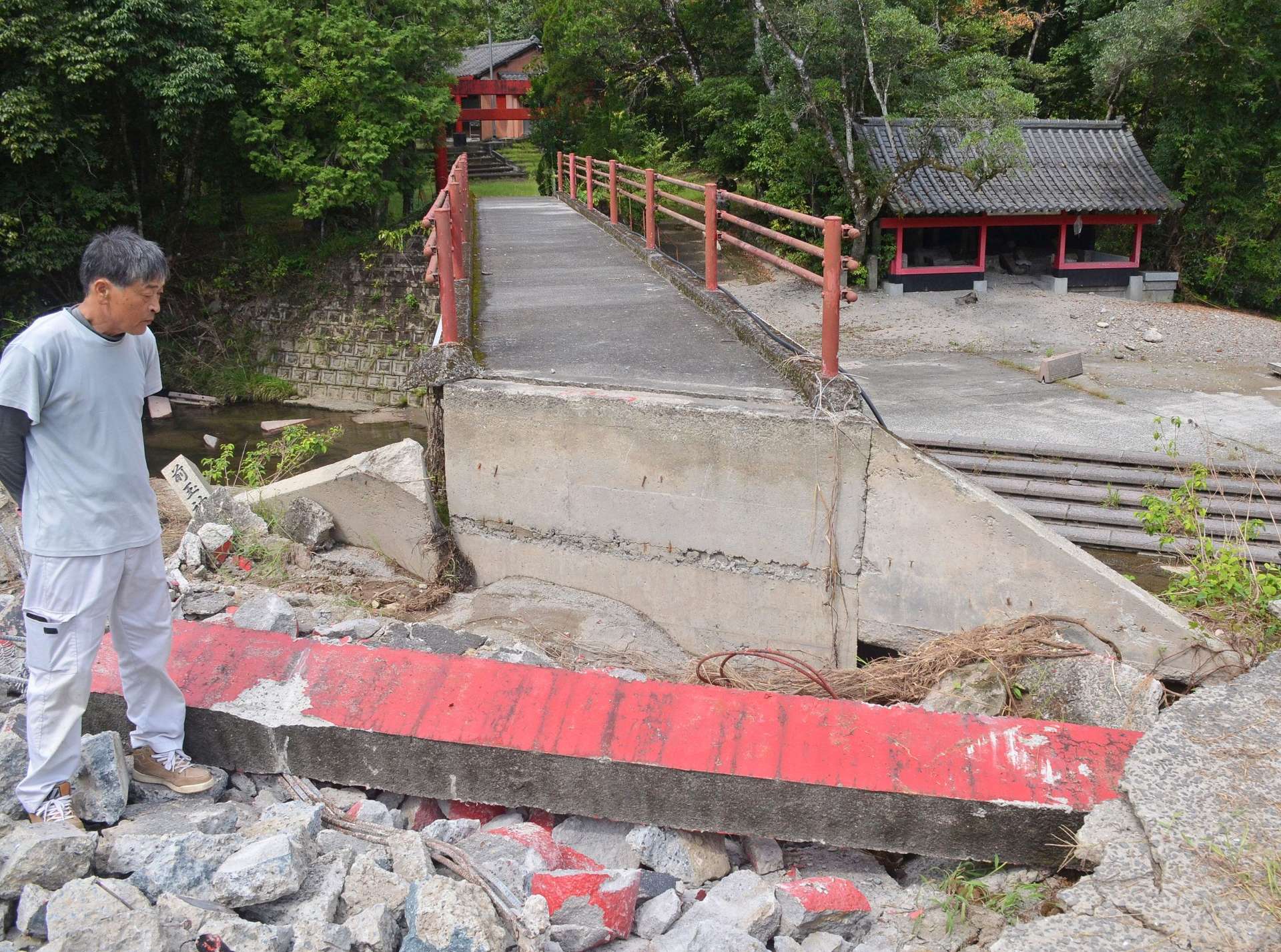 大雨で鳥居が倒壊し、境内へつながる橋の土台が崩れた前玉神社＝霧島市溝辺町三縄